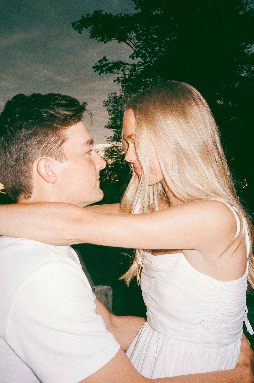South Carolina couple in white outfits in a nostalgic summer portrait in a grass field after a stress-free prenup process