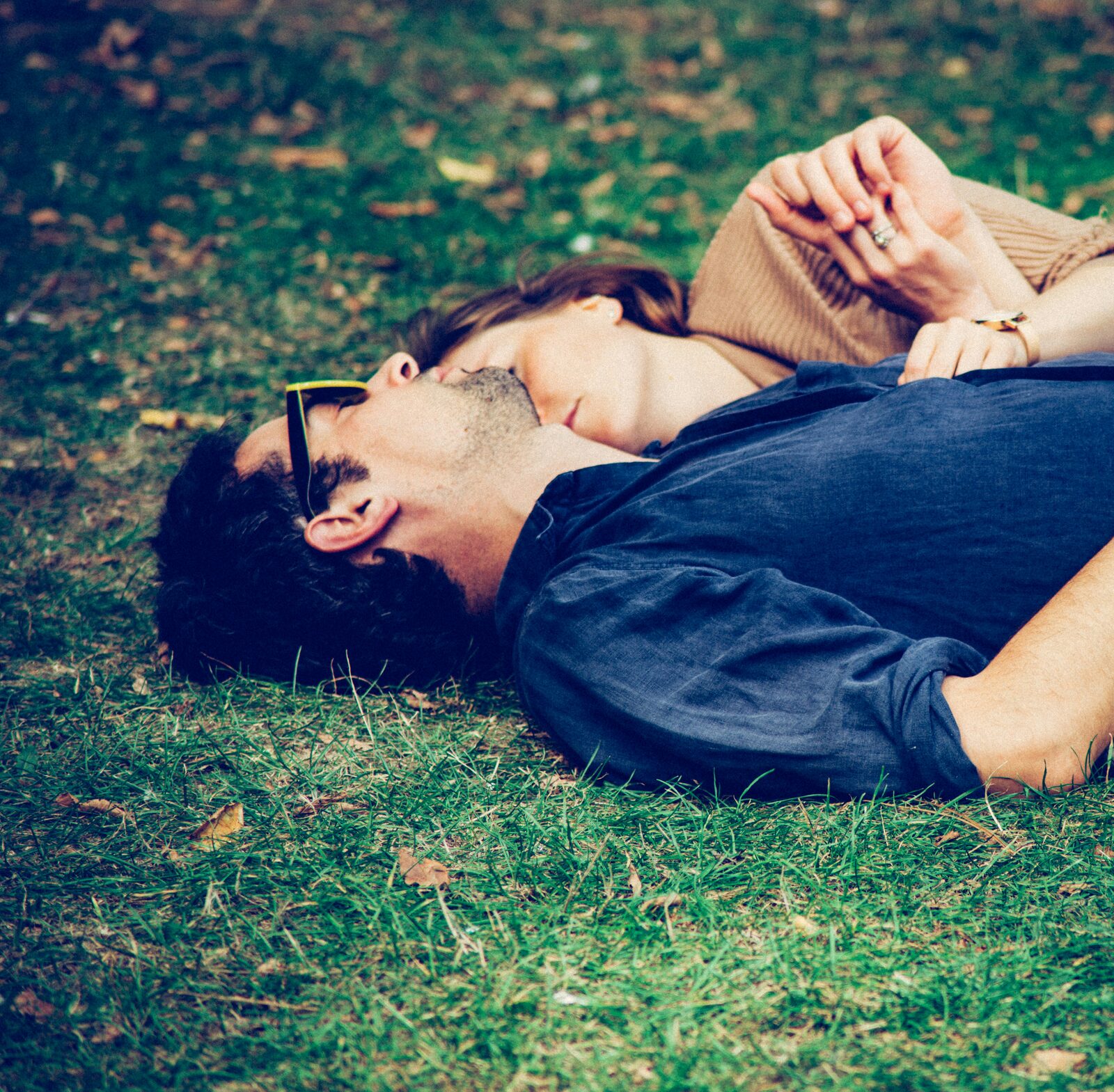 Engaged Ohio couple relaxing together in a park, wedding ring visible, preparing to build their prenup