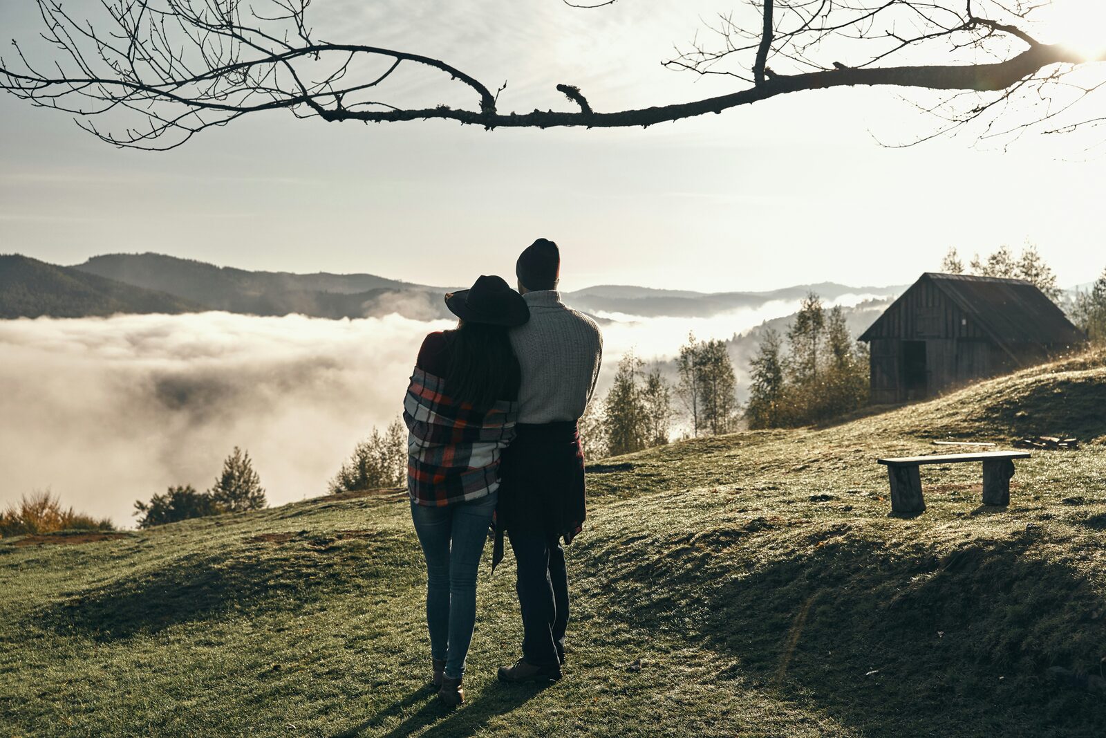 Tennessee couple embracing at sunrise above a fog-filled Smoky Mountains valley, protected with a HelloPrenup prenuptial agreement