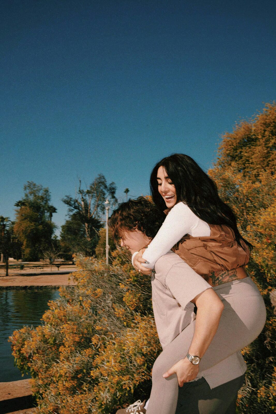 Maryland couple on a playful piggyback ride in the park after a stress-free prenup process