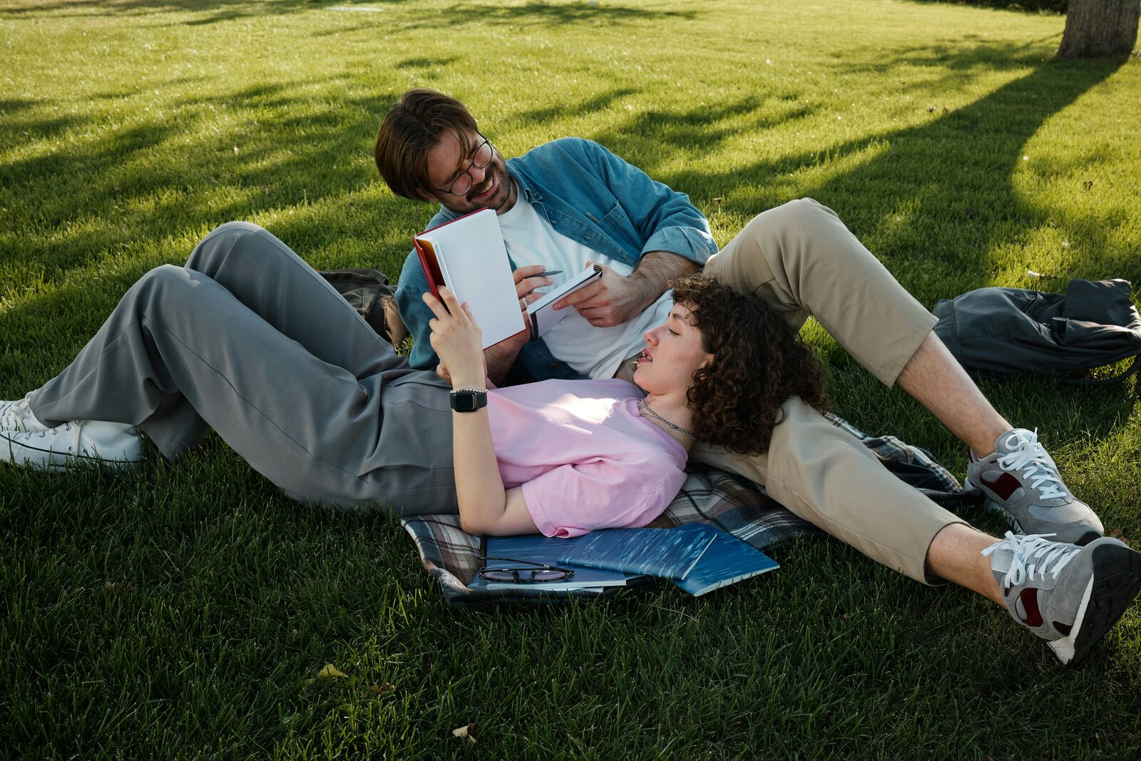 Minnesota couple sitting in the grass reading together, working through their prenup options