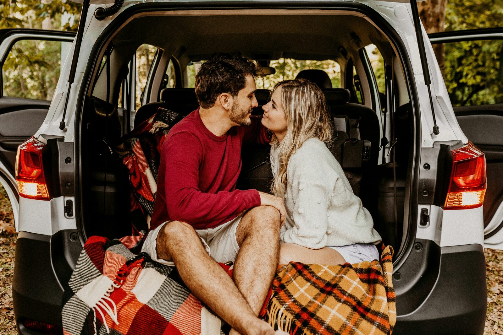 Engaged North Carolina couple on an autumn forest road trip, talking through how to get their prenup done
