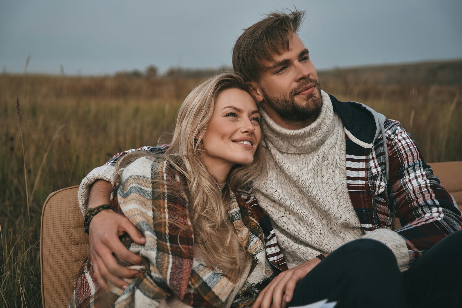 Tennessee couple wrapped in a plaid blanket in a golden field after completing their prenup