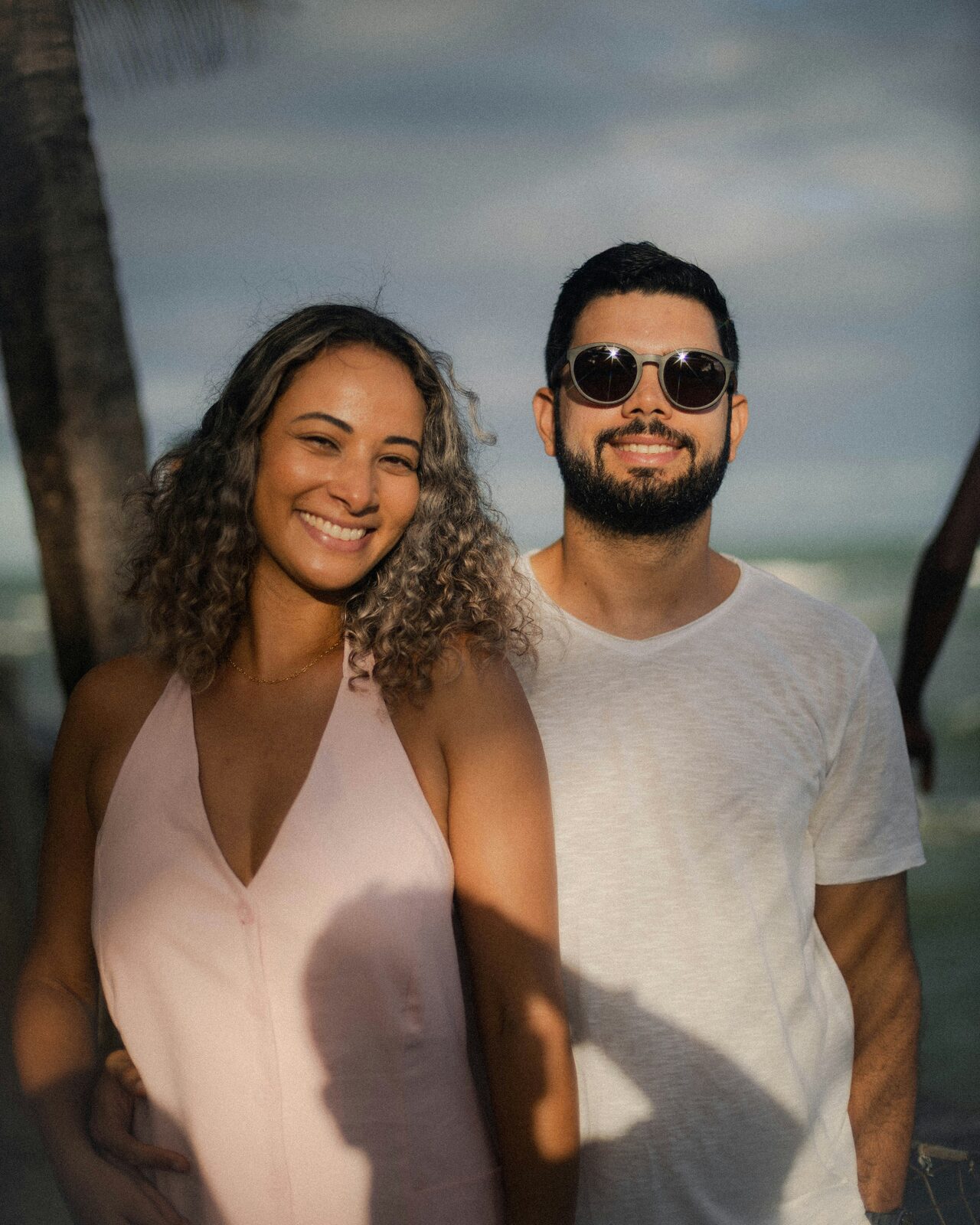 Engaged South Carolina couple at a palm-lined beach at sunset, preparing to build their prenup