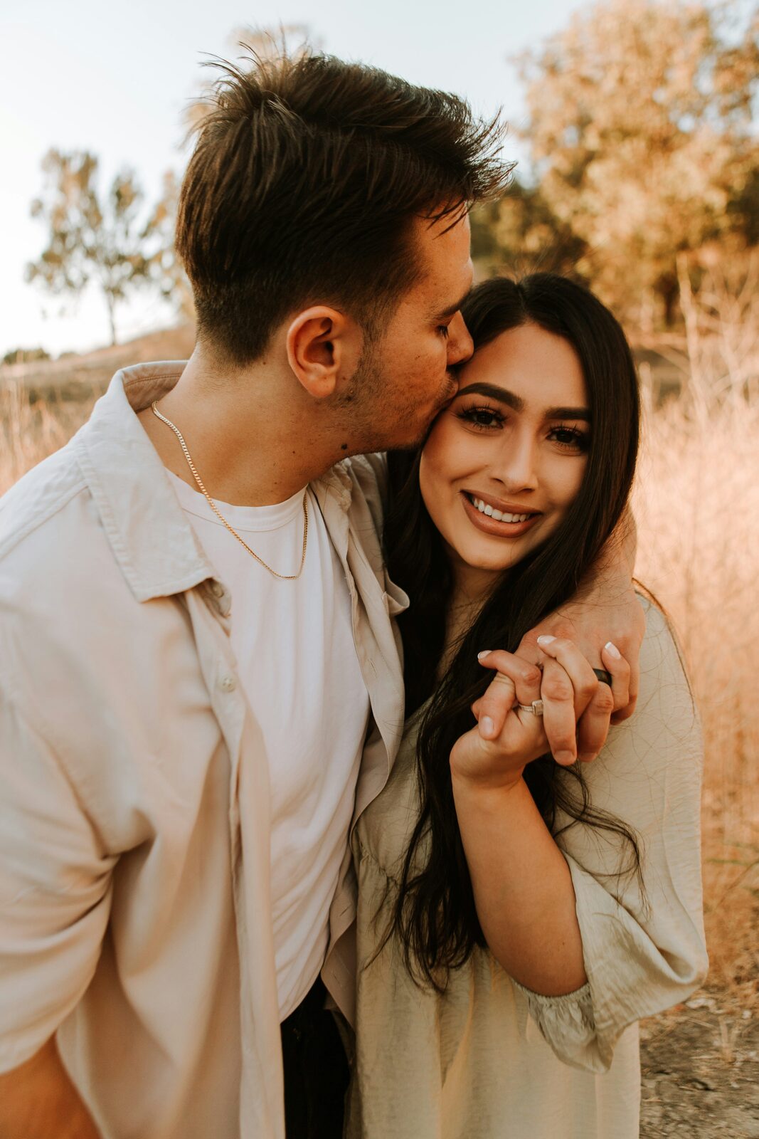 Engaged North Carolina couple sharing a golden hour kiss, exploring their prenup options