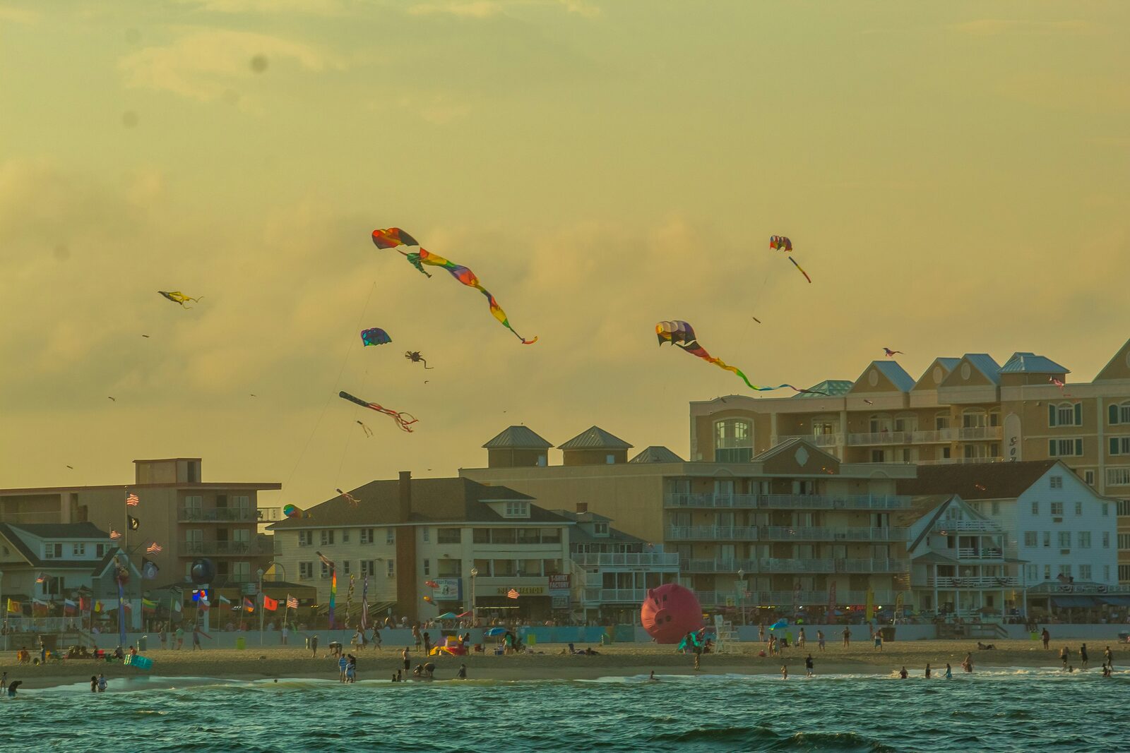 Ocean City, Maryland boardwalk and beach with colorful kites at summer sunset