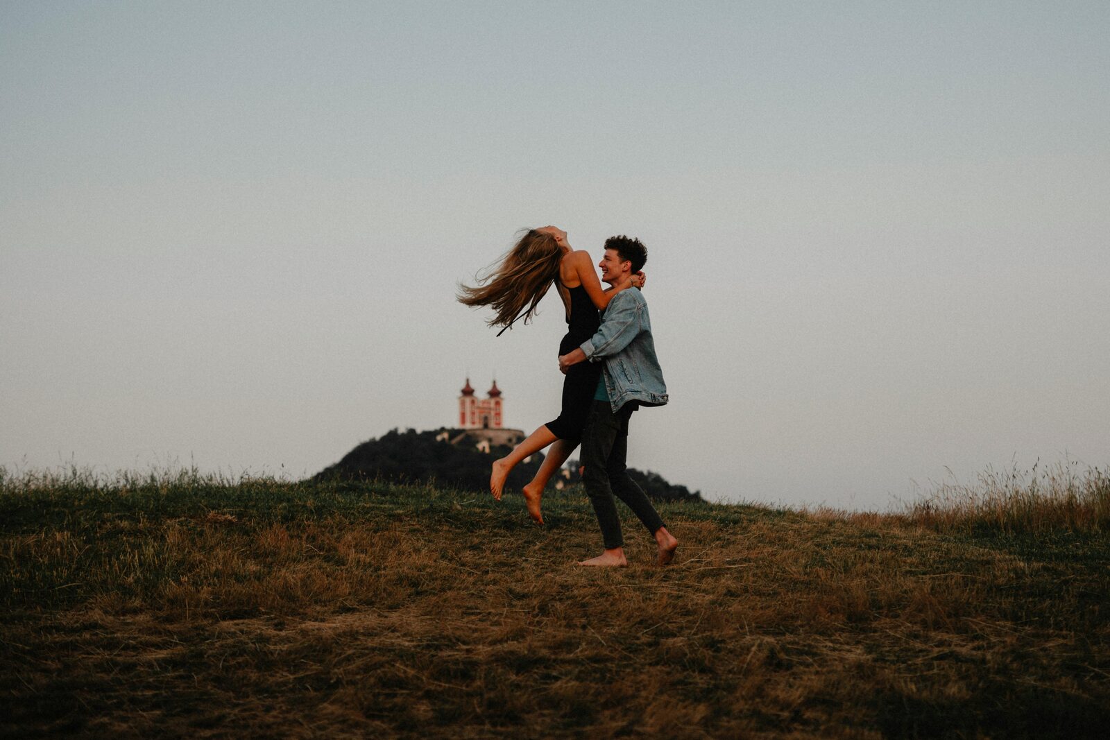 Tennessee couple twirling barefoot in a grass field after a stress-free prenup process