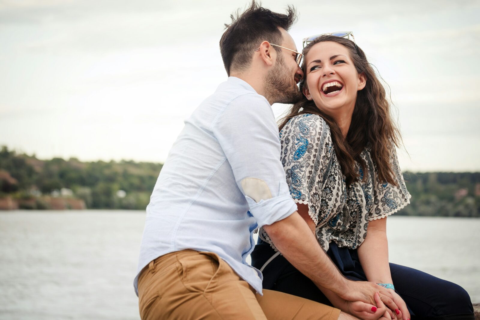 Maryland couple laughing at the lakefront while talking about marital property and alimony in their prenuptial agreement