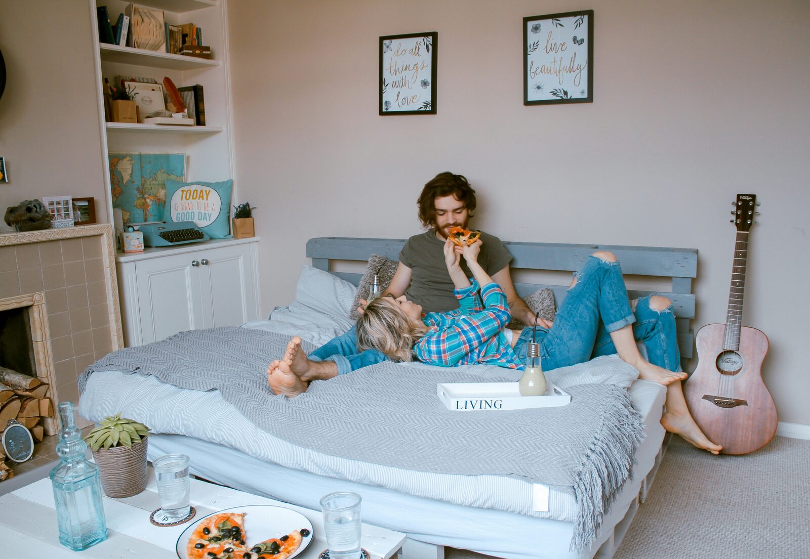 Missouri couple sharing pizza in bed in a cozy studio apartment while talking through their prenup options with HelloPrenup