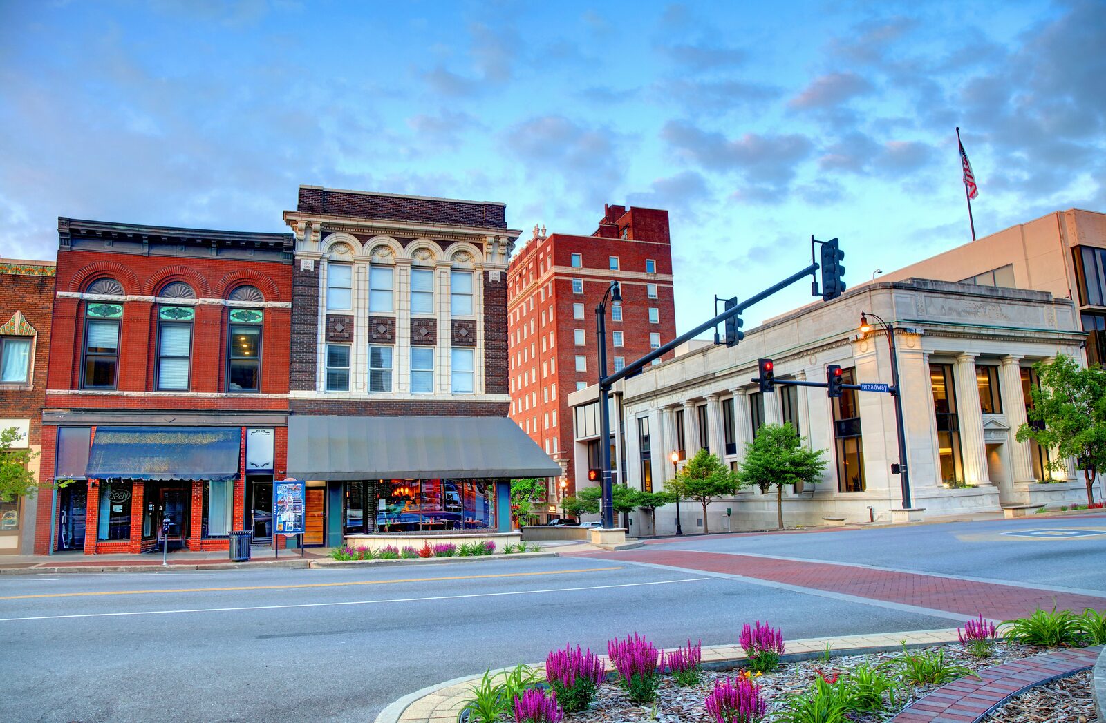 Historic downtown Missouri main street with brick buildings and a red-columned bank on a summer day, where couples sign and acknowledge their prenuptial agreements