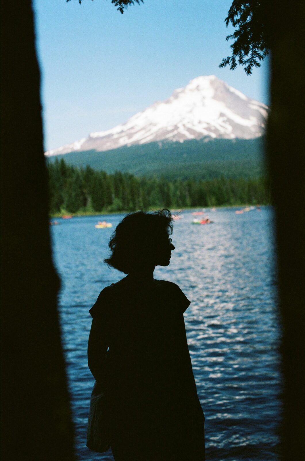 Kayaks and forest silhouetted against Mount Hood at Trillium Lake, Oregon