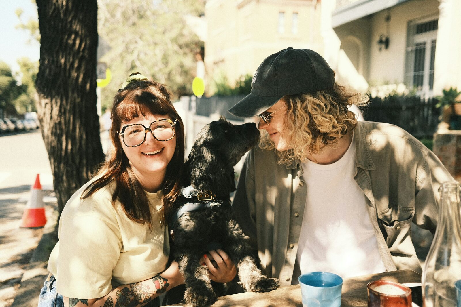 Utah couple with their black cocker spaniel at an outdoor cafe, exploring their prenup options