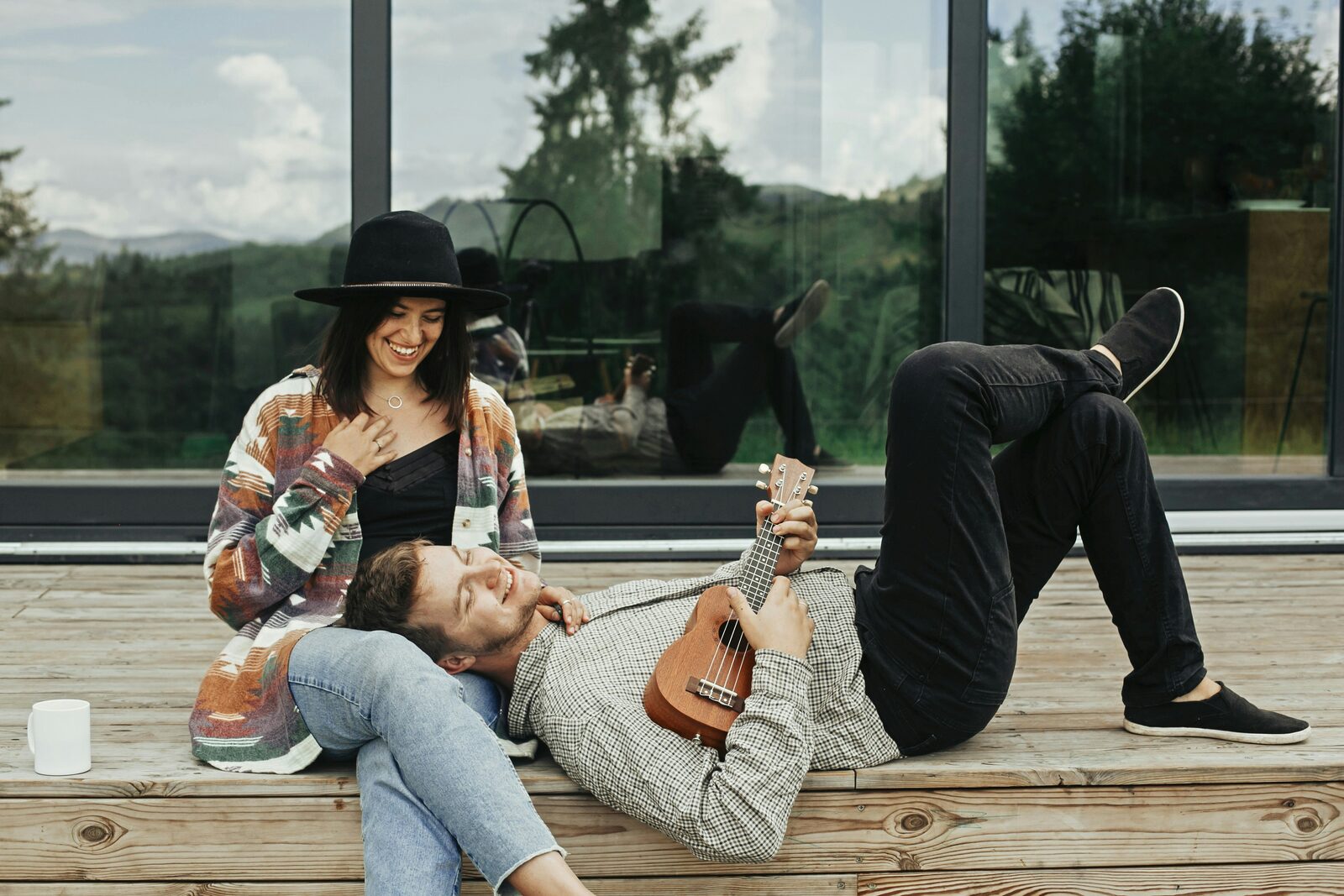 Engaged Indiana couple relaxing on a cabin deck with a ukulele, talking through how to get their prenup done