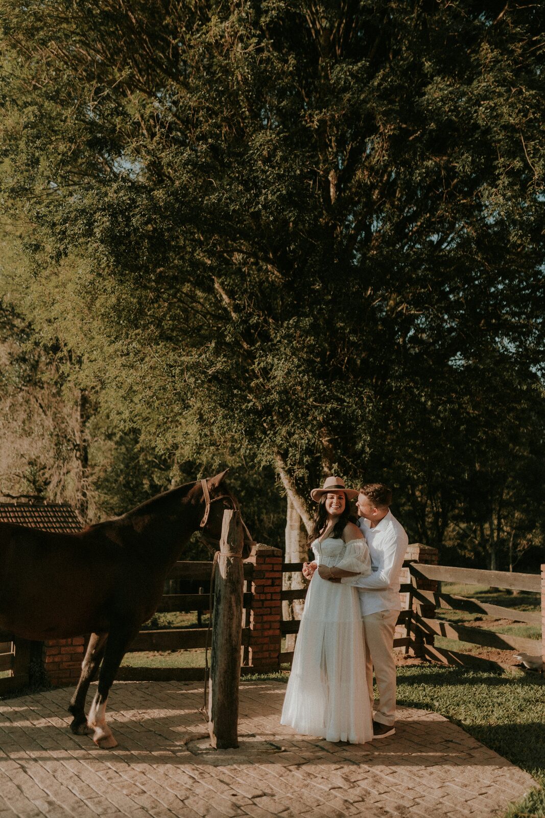 Couple at a ranch fence under the trees, reflecting the range of assets a prenup can protect