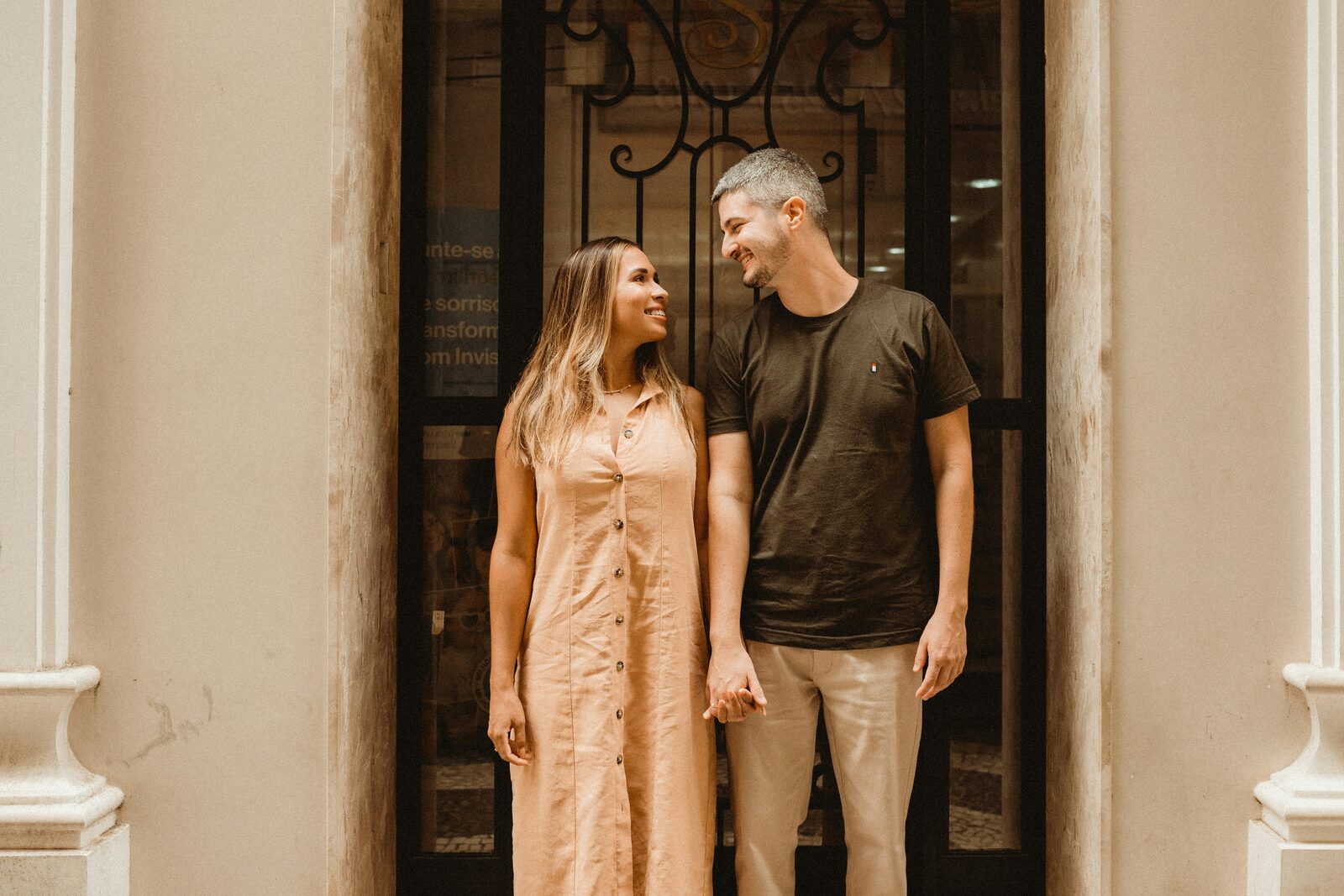 Kentucky couple holding hands and smiling in a doorway, thinking about the property they will share