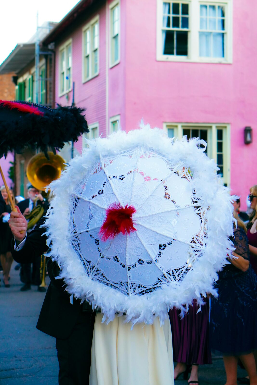 New Orleans second line wedding parade with a white lace parasol and brass band, celebrating after a stress-free prenup process